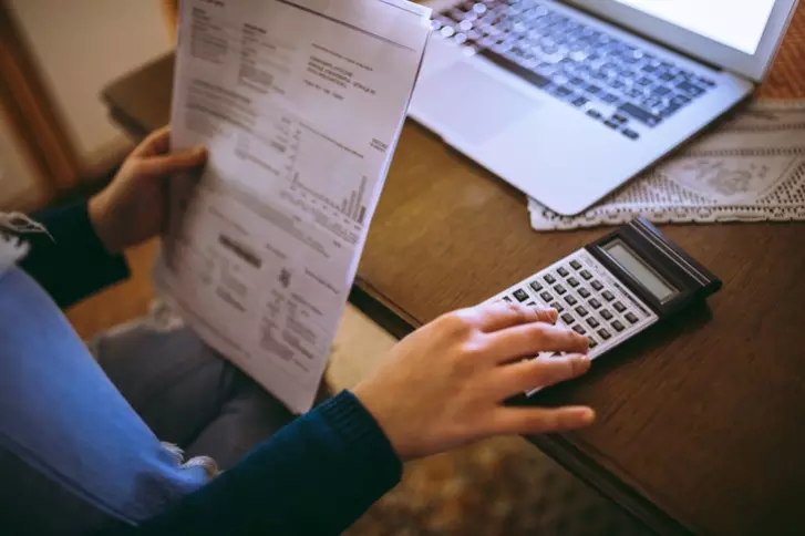 kobieta obliczająca rachunki za pomocą kalkulatora